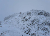 A fell runner makes his way through the snow as he runs up Ullock Pike near Keswick