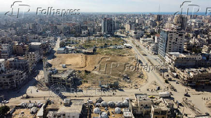 A drone view shows damaged and destroyed buildings as displaced Palestinians shelter in tents, following a ceasefire between Israel and Hamas, in Gaza City