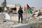 Palestinian Hamas policemen keep guard at their destroyed headquarters in Gaza City