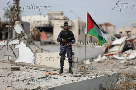 Palestinian Hamas policemen keep guard at their destroyed headquarters in Gaza City