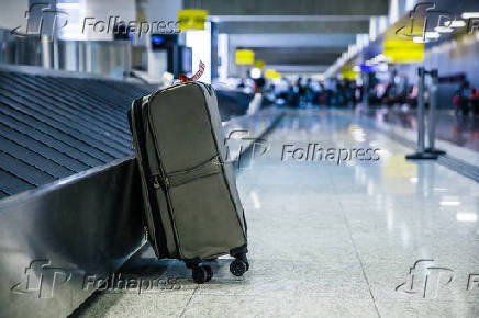 Mala de mo ao lado de esteira de bagagens no aeroporto de Guarulhos (SP)