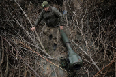 A serviceman prepares a howitzer to fire towards Russian troops at a frontline near the town of Chasiv Yar