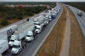 Trucks wait in line to cross into the United States, at the World Trade Bridge