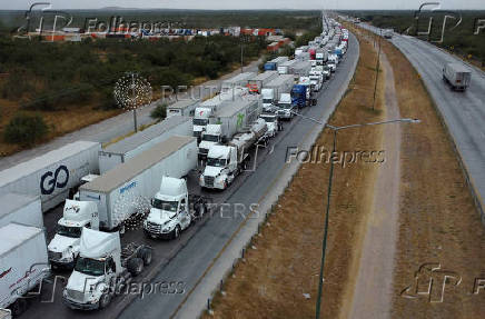 Trucks wait in line to cross into the United States, at the World Trade Bridge