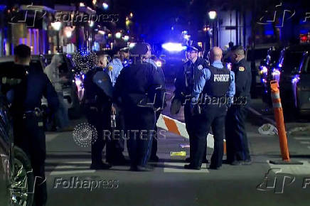 Police officers stand at the scene where a truck drove into a large crowd on Bourbon Street in New Orleans