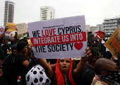 Migrants hold placards during a protest against Cypriot government changes in migration policy in Nicosia