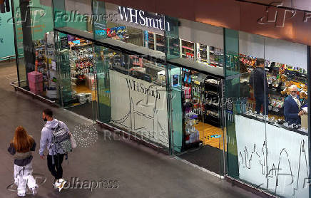 FILE PHOTO: People walk past a WH Smith store in London