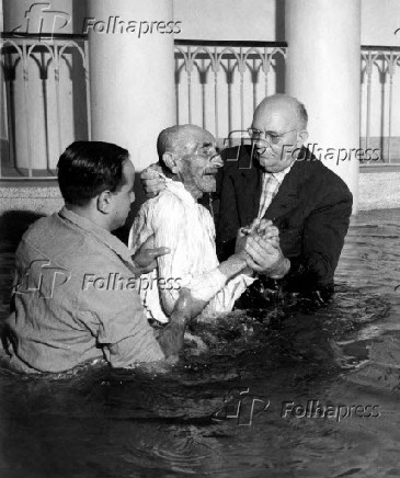 Pentecostais durante batismo de homem