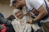 Palestinians mourn their dead after Israeli air strikes on central Gaza