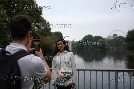 A person poses for a photo on the Blue Bridge in St James's Park, in London