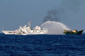 FILE PHOTO: Chinese Coast Guard vessels fire water cannons towards a Philippine resupply vessel Unaizah May 4 as it made its way to the Second Thomas Shoal in the South China Sea