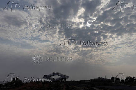 FILE PHOTO: People stand on a viewing platform overlooking the Taiwan strait at the 68-nautical-mile scenic spot, one of mainland China's closest points to the island of Taiwan, on Pingtan Island