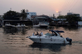 People cruise a boat on a lagoon near the Lekki-Ikoyi Link Bridge in Lagos