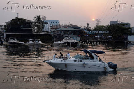 People cruise a boat on a lagoon near the Lekki-Ikoyi Link Bridge in Lagos