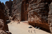 Visitors stand in front of the treasury site in the ancient city of Petra