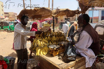 FILE PHOTO: A man buys fruits from a local vendor during the month of Ramadan, in the city of Omdurman