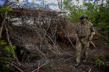 A Ukrainian serviceman of the 22nd Separate Mechanised Brigade walks at an artillery position on the outskirts of Chasiv Yar