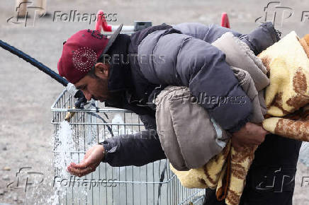 Sadiq Tarakhil, a 29-year-old migrant from Afghanistan, drinks water in a camp in Grande Synthe