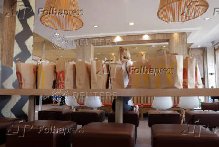 A McDonald's customer stands next to bags with menus after buying them in a McDonald's restaurant, in Malaga