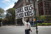 A demonstrator holds a sign across from the Columbia University campus with a student protest encampment in support of Palestinians, in New York City