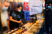 A person prepares food at her stall in Taipei
