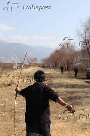 Arqueiro atira com a arma tradicional, de bambu, na cidade de Parto, em Buto