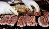 FILE PHOTO: A worker prepares pork meat in a food truck in Sao Paulo