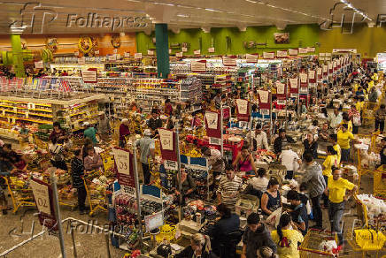 Consumidores fazem fila para passar em caixa de supermercado