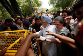 FILE PHOTO: India's main opposition Congress party president Gandhi and former Prime Minister Singh cross a police barricade during what the party calls as a 