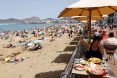Tourists eat on a terrace next to Las Canteras Beach in Las Palmas de Gran Canaria
