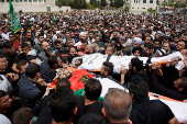 Mourners carry the bodies of two Palestinians who were killed during an Israeli settlers' attack on Aqraba
