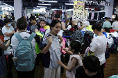 FILE PHOTO: Customers shop at a discount clothing shop in Beijing