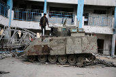 Palestinians look at damaged Israeli military vehicles left behind by Israeli forces in Rafah