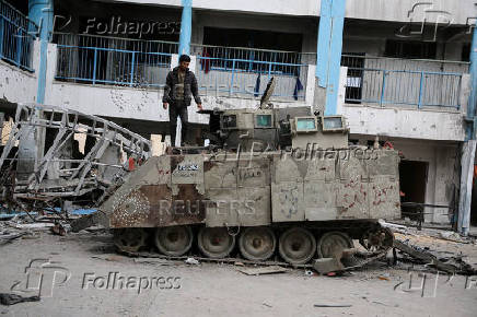 Palestinians look at damaged Israeli military vehicles left behind by Israeli forces in Rafah