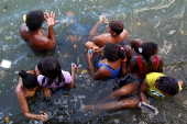 Crianas e adolecentes nadam no rio Capibaribe em Recife