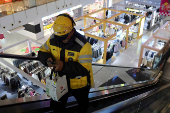 Delivery worker picks up a food order at a shopping mall in Beijing