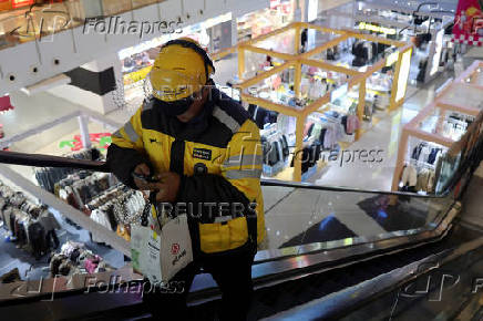 Delivery worker picks up a food order at a shopping mall in Beijing