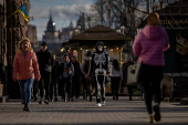 A man handing out promotional flyers wears a skeleton costume as he walks along Khreshchatyk Street in Kyiv