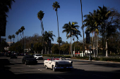 A man drives a classic car on Wilshire Boulevard