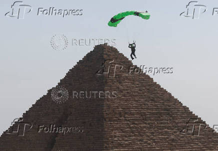 Professional skydivers fly over the historical site of Giza Pyramids, during Egypt International Skydiving Festival 