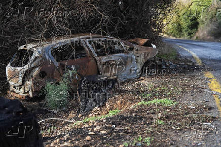 A burnt car is seen at the side of a road near the Israeli border with Lebanon amid cross-border hostilities between Hezbollah and Israel