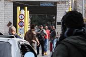 People make their way as they attempt to cross into Syria after Syrian rebels announced that they have ousted President Bashar al-Assad, near Masnaa Border Crossing