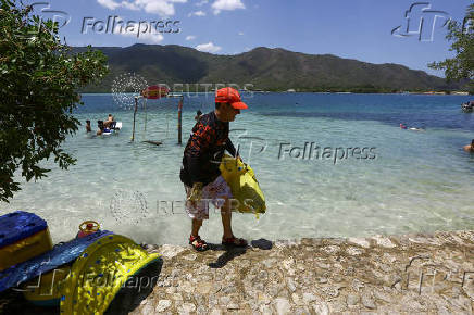 Activists and volunteers collect garbage during the cleanup operation as part of World Beach Day, in La Cienega