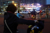 Child sits in a bicycle at an intersection in Beijing