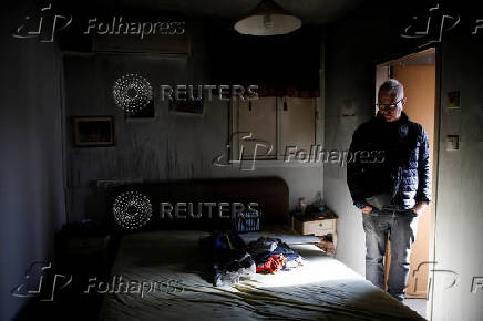 People inspect the damage caused by projectiles fired from Lebanon, following the ceasefire between Israel and Iran-backed group Hezbollah, in Metula