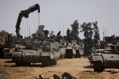 Israeli military vehicles are parked near the Israel-Gaza border