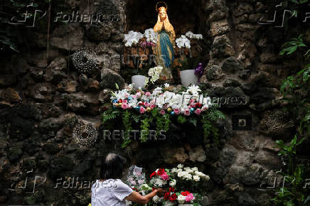 A woman arranges flowers to prepare for the Christmas mass at the Jakarta Cathedral in Jakarta