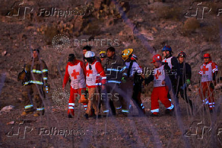 Rescue personnel carry the body of an agent of the National Institute of Migration (INM), in Ciudad Juarez