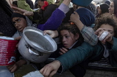 Displaced Palestinians collect donated food in Khan Yunis, southern Gaza