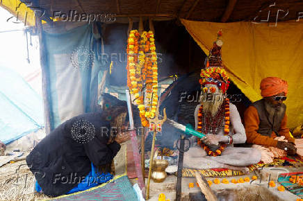 A Naga Sadhu or Hindu holy man blesses a devotee inside his tent during the 